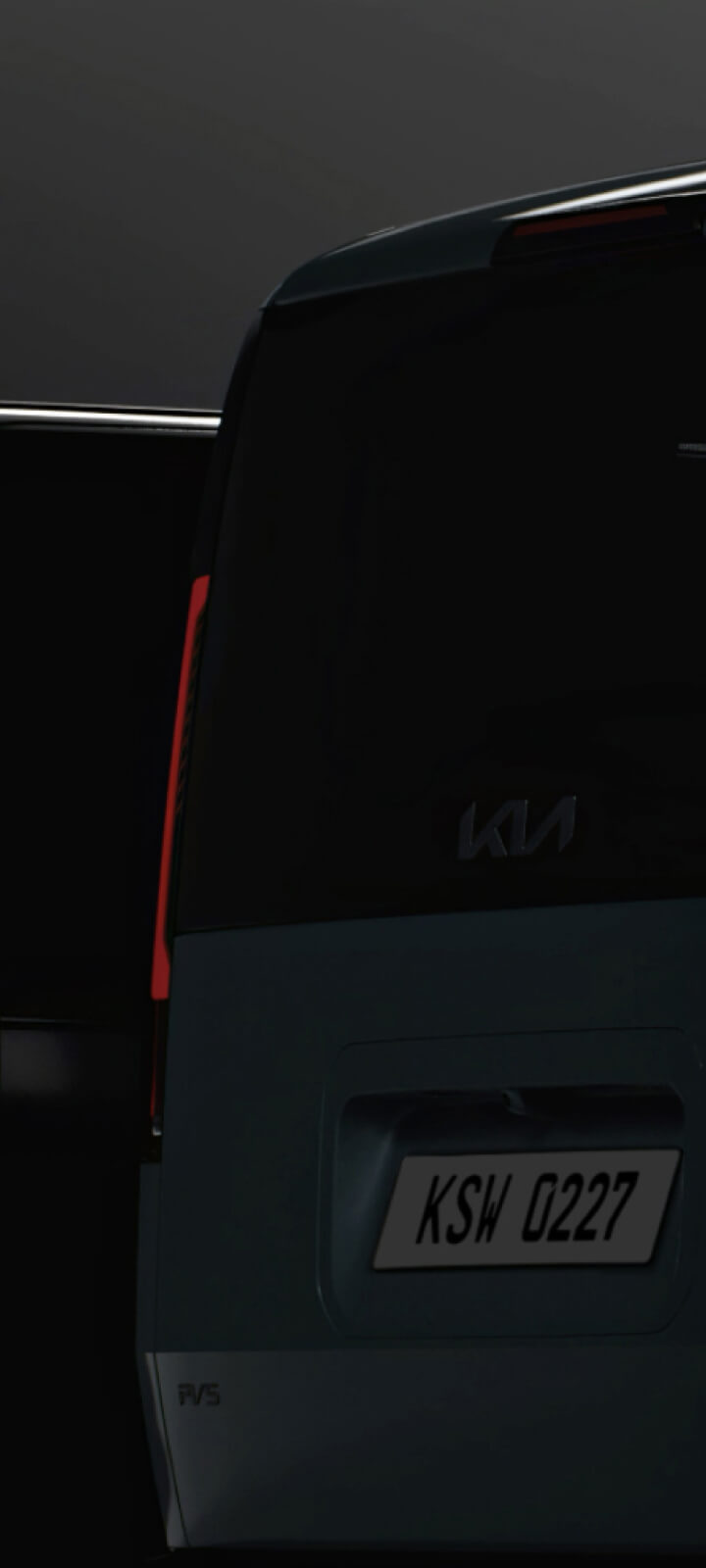 Heckansicht des Kia PV5 Passenger bei schwachem Licht – die Rückleuchten stehen im Fokus.